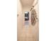 Hallway with tiled floor leads to a bedroom with a four-poster bed; artistic wooden decor on the wall at 19951 Quinlan St, Orlando, FL 32833