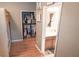 Hallway view reveals a built-in closet and bathroom, accented by hardwood flooring for a functional and stylish transition at 19951 Quinlan St, Orlando, FL 32833
