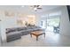Bright living room with a gray sectional sofa leading to a patio and adjacent kitchen at 19951 Quinlan St, Orlando, FL 32833