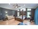 Large main bedroom features a four-poster bed, a sitting area, wood floors, and large windows at 19951 Quinlan St, Orlando, FL 32833