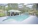 A screened-in pool with shaded seating and surrounding mature trees at 19951 Quinlan St, Orlando, FL 32833