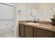 Bathroom with dark wood vanity, white countertops, and a shower-tub combo at 2400 Addison Creek Dr, Kissimmee, FL 34758