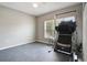 Bedroom with neutral walls, gray floors, a large window, and a treadmill with exercise equipment at 2400 Addison Creek Dr, Kissimmee, FL 34758