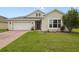 Charming single-story home featuring a well-manicured lawn, attached two car garage, and neutral toned stucco exterior at 2400 Addison Creek Dr, Kissimmee, FL 34758
