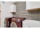 Laundry room featuring updated washer, dryer, wash sink, and modern wood accent wall at 2400 Addison Creek Dr, Kissimmee, FL 34758