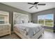 Bright main bedroom with decorative headboard, dual windows, and wood-look flooring at 2400 Addison Creek Dr, Kissimmee, FL 34758