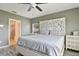 Main bedroom with decorative headboard, light-colored walls, and connecting updated bathroom at 2400 Addison Creek Dr, Kissimmee, FL 34758