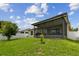 A lovely view of the backyard showing the lush lawn, the treeline, and the screened-in lanai at 2409 Martins Run, Tavares, FL 32778