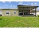 Backyard featuring green lawn and screened patio, ideal for outdoor living and entertaining at 2409 Martins Run, Tavares, FL 32778