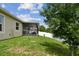 Landscaped backyard with a green lawn, white fence, and screened in patio, perfect for outdoor gatherings at 2409 Martins Run, Tavares, FL 32778