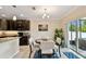 Bright dining area with view to the kitchen and access to screened patio at 2409 Martins Run, Tavares, FL 32778