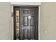 Stylish black front door featuring decorative wolf door knocker and sidelight window at 2409 Martins Run, Tavares, FL 32778