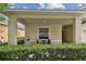 Charming covered porch with a cozy seating area and view of the lush front garden at 2409 Martins Run, Tavares, FL 32778