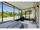 Screened-in lanai featuring an outdoor grill and seating area with a view of the backyard at 2409 Martins Run, Tavares, FL 32778