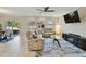 Bright living room with a ceiling fan, a plush sofa set, and a wall-mounted TV at 2409 Martins Run, Tavares, FL 32778
