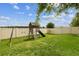Fenced backyard featuring a wooden playset with swings and a slide on a grassy lawn at 2777 Monticello Way, Kissimmee, FL 34741