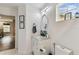 Bathroom with a white vanity, oval mirror, and modern fixtures; decorative artwork accents at 2777 Monticello Way, Kissimmee, FL 34741