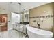 Modern bathroom with a soaking tub, glass shower, a dual vanity, and mosaic tile accents at 2777 Monticello Way, Kissimmee, FL 34741