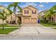Charming two-story home featuring a well-maintained lawn, mature palm trees, and a two-car garage at 2777 Monticello Way, Kissimmee, FL 34741
