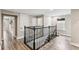Upstairs hallway with wood floors, decorative railing, and natural light from the windows at 2777 Monticello Way, Kissimmee, FL 34741