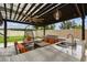 Outdoor kitchen with granite countertops, sink, and seating area beneath a pergola at 2777 Monticello Way, Kissimmee, FL 34741
