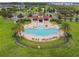 A high-angle shot of a well-maintained community pool surrounded by greenery and comfortable seating options at 2777 Monticello Way, Kissimmee, FL 34741