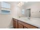 Bathroom with dual sinks, window and wood cabinetry at 3578 Cortland Dr, Davenport, FL 33837