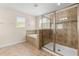 Bathroom featuring a glass enclosed shower and soaking tub with tiled accents and a window at 3578 Cortland Dr, Davenport, FL 33837
