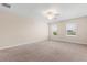Bright bedroom features carpeted floors, neutral-colored walls, two windows, and a ceiling fan at 3578 Cortland Dr, Davenport, FL 33837