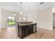 Kitchen island with granite countertops, dark wood cabinets, and stainless steel appliances at 3578 Cortland Dr, Davenport, FL 33837