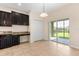 Bright kitchen nook with dark cabinetry, granite countertops and sliding glass doors leading to the patio at 3578 Cortland Dr, Davenport, FL 33837
