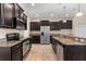 Kitchen featuring an island with granite countertops, dark wood cabinets, and stainless steel appliances at 3578 Cortland Dr, Davenport, FL 33837