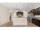 Kitchen featuring an island with granite countertops, dark wood cabinets, and stainless steel appliances at 3578 Cortland Dr, Davenport, FL 33837