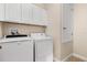 Laundry room with washer, dryer, and cabinets, providing ample storage and convenience at 3578 Cortland Dr, Davenport, FL 33837