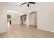 Spacious living room featuring tile floors, neutral walls, and elegant archways leading to kitchen and stairs at 3578 Cortland Dr, Davenport, FL 33837