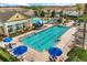 Aerial view of a luxurious swimming pool area surrounded by lounge chairs and blue umbrellas at 3578 Cortland Dr, Davenport, FL 33837