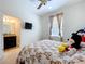 Bedroom featuring a bed with a patterned quilt and a wall-mounted television at 3744 Quaint Ln, Clermont, FL 34711
