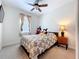 Cozy bedroom with a ceiling fan and comfortable, patterned bedding at 3744 Quaint Ln, Clermont, FL 34711