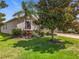 Attractive home exterior with mature trees, manicured lawn and stone accents at 3744 Quaint Ln, Clermont, FL 34711
