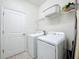 Laundry room with washer, dryer, tile flooring and wire shelf, offering convenience and functionality at 3744 Quaint Ln, Clermont, FL 34711
