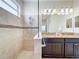 Main bathroom featuring a walk-in shower and double sink vanity with granite countertop and tiled backsplash at 3744 Quaint Ln, Clermont, FL 34711