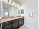 Main bathroom featuring a double sink vanity with granite countertop, tile floor, and vanity mirror at 3744 Quaint Ln, Clermont, FL 34711