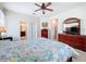 Spacious main bedroom features a ceiling fan, dresser with mirror, and access to the main bathroom at 3744 Quaint Ln, Clermont, FL 34711