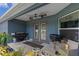 Covered back porch with ceiling fans, grill and outdoor seating area at 382 Lake St, Umatilla, FL 32784