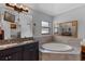 Bright bathroom featuring double sinks, granite countertops, a tub with tile surround and a separate shower at 382 Lake St, Umatilla, FL 32784