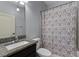 Cozy bathroom features a granite sink, toilet, and a shower with a decorative patterned shower curtain at 382 Lake St, Umatilla, FL 32784