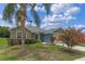 Charming home featuring stone accents, a well-manicured lawn, and vibrant landscaping at 382 Lake St, Umatilla, FL 32784
