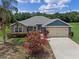Charming single-story home with stone accents, a two-car garage and flowering bushes at 382 Lake St, Umatilla, FL 32784