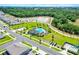Aerial view of a modern residential neighborhood with community pool, sidewalks and natural backdrop at 4413 Lions Gate Ave, Clermont, FL 34711