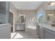 Bathroom with double sinks, gray cabinets, a garden tub and separate shower at 4413 Lions Gate Ave, Clermont, FL 34711